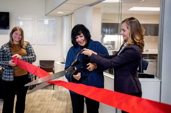 Cutting a celebratory ribbon are, from left, Dr. Kristen Woods, president of Trinity Health Medical Group; GVSU President Philomena V. Mantella; and Kate Harmon, GVSU acting assistant vice president for Student Affairs.