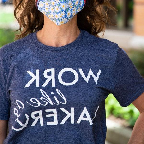 A woman wearing a blue "Work like a Laker" t-shirt and face covering.
