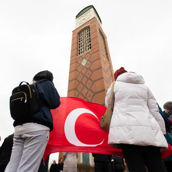 Students hold the Turkish flag in front of the Cook Carillon Tower during a vigil.